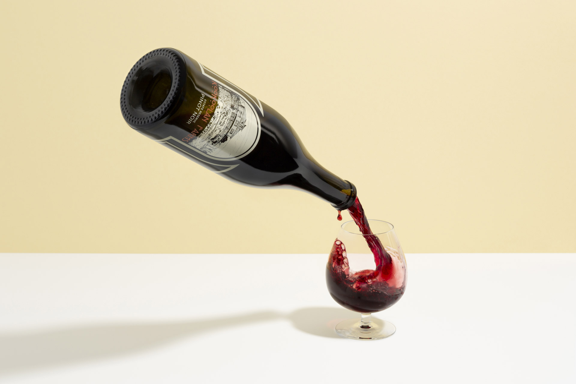 Rotweinflasche die in der Luft gleichzeitig ein glass Wein füllt.