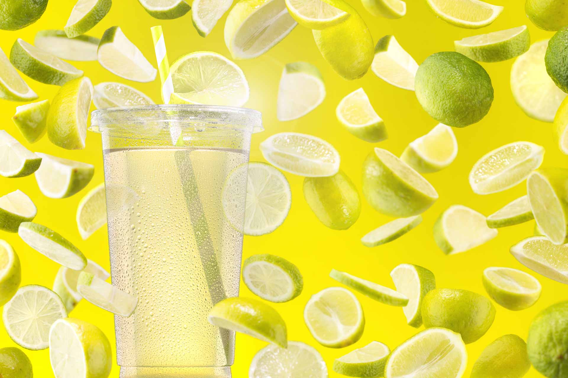 Limonaden Getränk mit Zitronen und Limetten im Hintergrund